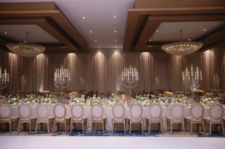 Ballroom with long tables, oval-back chairs and crystal chandeliers