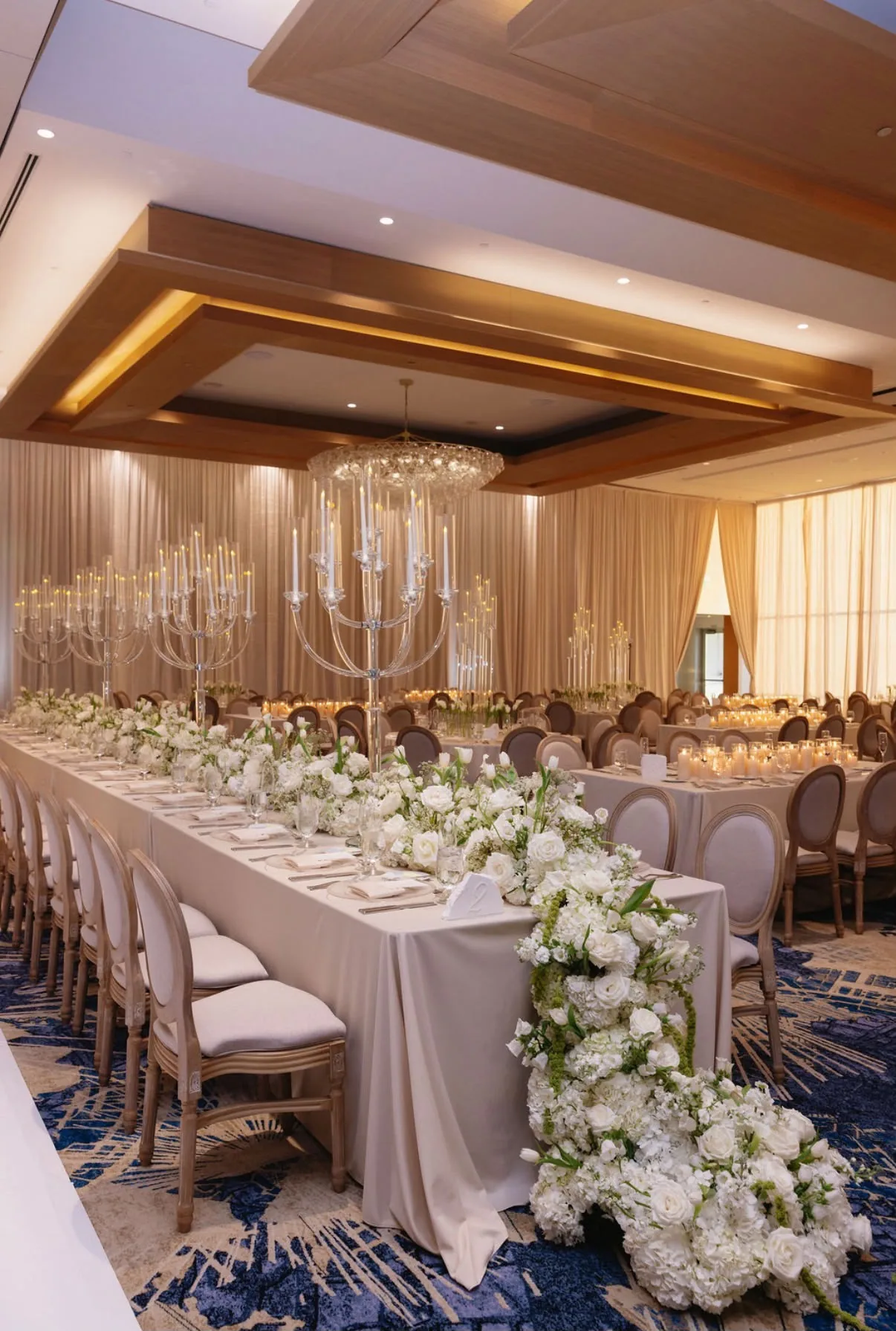 Grand ballroom reception with crystal candelabras and cascading white florals